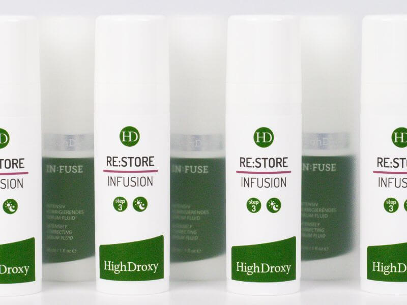 Bottles of RE:STORE Infusion Serum against a blurred background